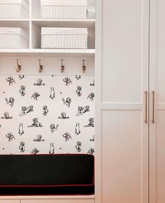 a white closet with black and red wallpaper next to a shelf filled with baskets