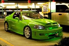 a green car parked in front of a gas station