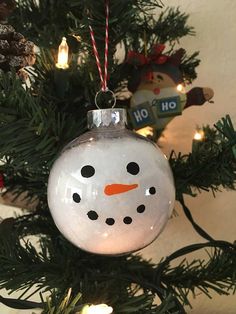 a snowman ornament hanging from a christmas tree