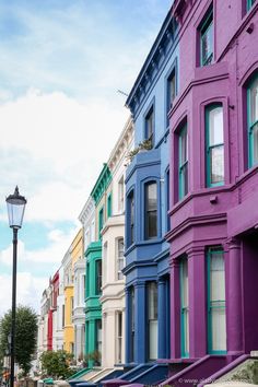 a row of multi - colored buildings on a street with a lamp post in the foreground