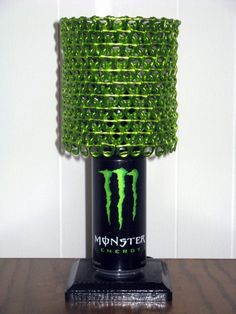 a green monster energy drink bottle sculpture on a wooden table