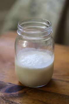 a glass jar filled with liquid sitting on top of a wooden table