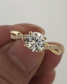 a person holding a ring with a diamond in it's center and two diamonds on the side