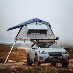 a car with a tent attached to it's roof