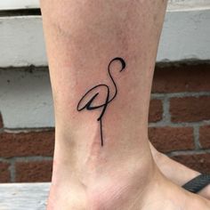 a flamingo tattoo on the ankle is shown in black ink, and it has a long neck