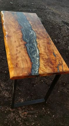 a wooden table with metal legs and a river in the center on top of it