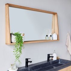 a bathroom sink with a mirror above it and soap dispensers on the counter