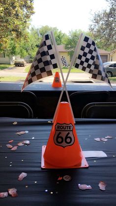 an orange traffic cone sitting on top of a black table next to a checkered flag