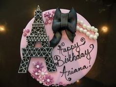 a birthday cake decorated with the eiffel tower and pearls