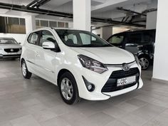 a white car parked in a garage next to other cars