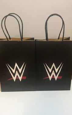 two black shopping bags with white and red logos on them are sitting next to each other