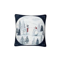 a white and blue pillow with snowmen on it, surrounded by pine trees in the background