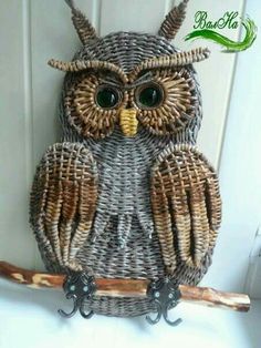 an owl made out of wicker sitting on a branch