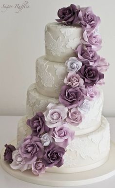 a three tiered cake with purple flowers on top