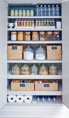 an organized pantry with lots of items in baskets and containers on the bottom shelf, along with toilet paper