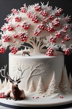 a cake decorated with white frosting and red berries on top is topped with an antler's head