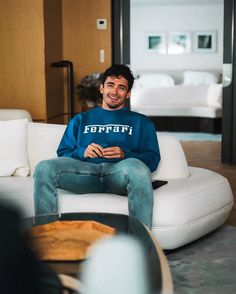 a man sitting on top of a white couch