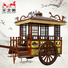 an old wooden cart with dragon decorations on the roof and wheels, sitting in front of a white background