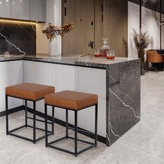 two stools are in the middle of a kitchen with marble countertops and cabinets