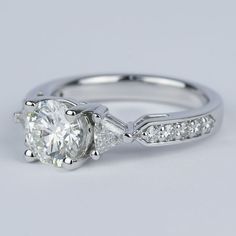 a white gold engagement ring with three stones on the side and an oval diamond in the center