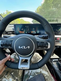 a person is holding the steering wheel of a car while it's on display