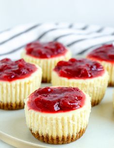 mini cheesecakes with strawberry jelly topping on a white and pink plate, ready to be eaten