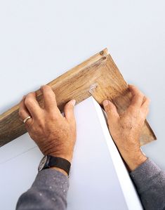 a man is working on a piece of wood