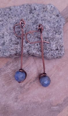 a pair of earrings sitting on top of a rock