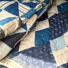 a blue and white quilt on top of a bed