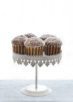 three cupcakes on a cake stand with frosting