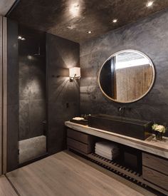 a bathroom with a sink, mirror and shower stall in the middle of the room