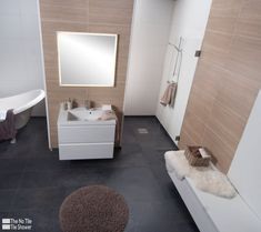 a bathroom with a sink, mirror and bathtub next to a rug on the floor