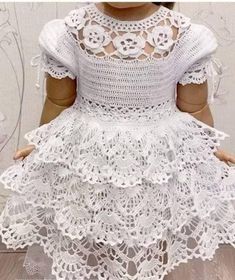 a doll wearing a white crochet dress