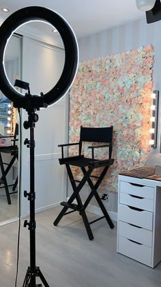 a photo studio setup up with a camera and tripod in front of a flowered wall