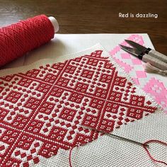 red and white cross - stitching is being worked on