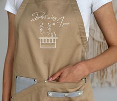 a woman is wearing an apron and has her hand in the pocket of her pants