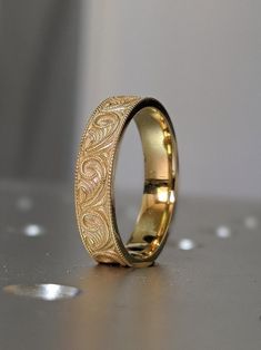 a gold wedding ring sitting on top of a table