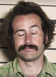 a man with his eyes closed in front of a mugshot