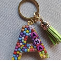 a letter shaped keychain with candy beads and tassels on the front