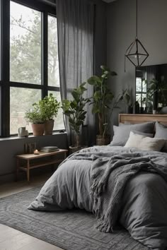 a large bed sitting next to a window with plants in the corner on top of it