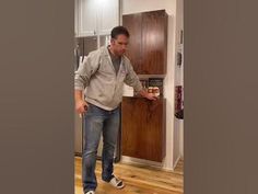 a man standing in front of a refrigerator freezer next to a kitchen counter top