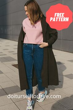 a woman standing on the sidewalk with her hands in her pockets, wearing jeans and a pink shirt