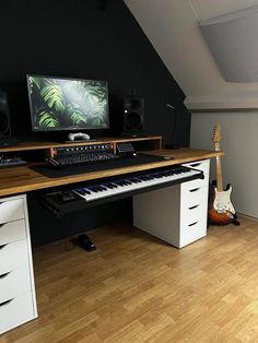 there is a computer and keyboard on the desk in this room with hard wood flooring