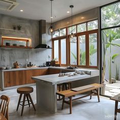 a kitchen with an island and stools in front of windows that look out onto the outdoors