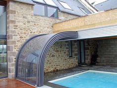 a house with a swimming pool in front of it and an enclosed patio next to it