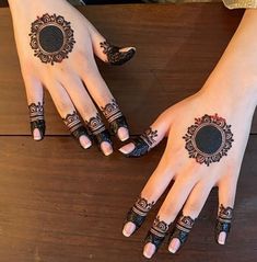 two hands with henna tattoos on them