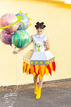 a woman in a costume holding some balloons