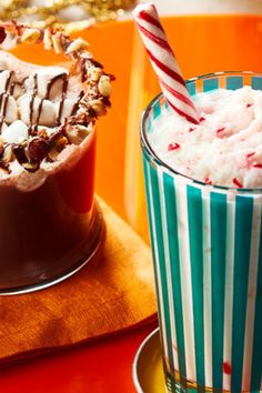 two glasses filled with ice cream and candy canes next to each other on a table