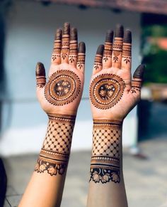 two hands with henna designs on them