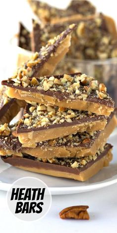 chocolate caramel bars stacked on top of each other with pecans in the background